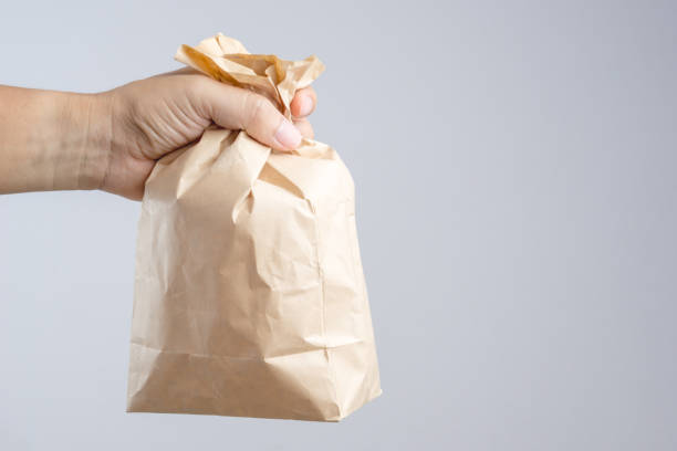 istock Hand holding crumble brown paper bag 1188522302