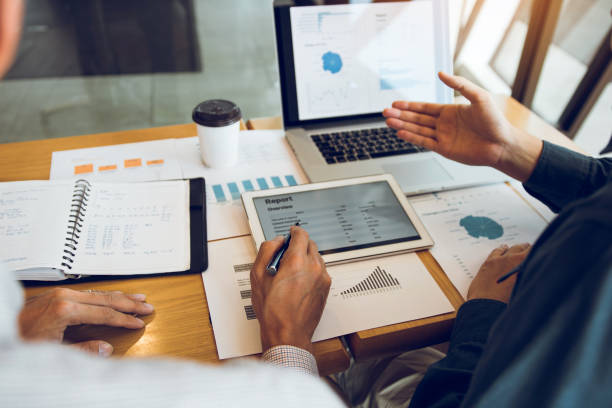 istock Business partnership coworkers analysis cost work progress and using a tablet to graph company financial budget report and planning for future in office room. 1188527733