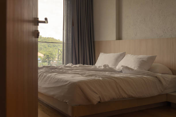istock wrinkled white blanket with soft pillows on comfortable bed in the morning. messed up after nights sleep 1188528585