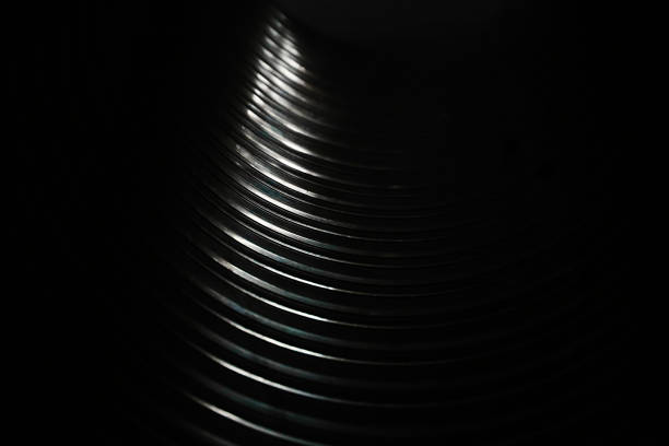 Black and white texture of inside big metal pipe on sunlight. Transition from dark to light color. Festive elegant background for design. Glare reflected light.
