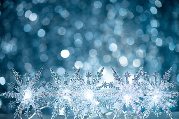 Glass snowflakes on defocused lights background with copy space
