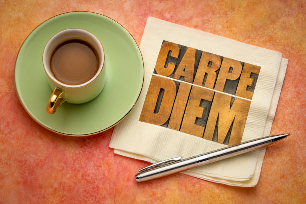 Carpe Diem  - enjoy life before it is too late, existential cautionary Latin phrase by Horace -  text in vintage letterpress wood type printing blocks on a napkin  with a cup of coffee