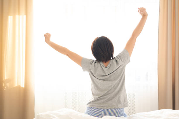 istock Woman stretching in bed after wake up, back view 1188534227