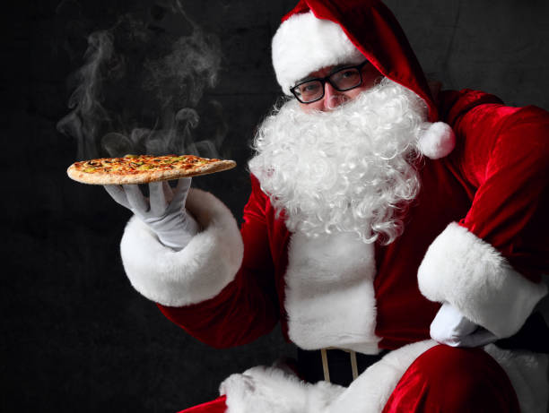Happy Santa Claus is seating holding big hot steaming pizza offering, serving, brought us. New year and Xmas fast food stock photo