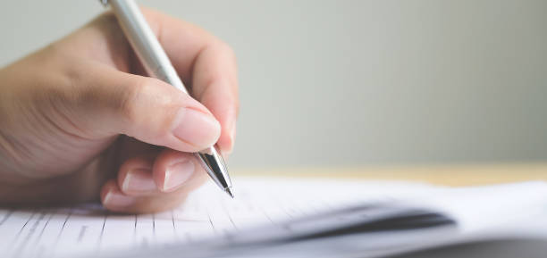 main de l'homme signant la signature remplissant dans l'accord de contrat d'affaires de document de formulaire de demande - remplir un formulaire photos et images de collection