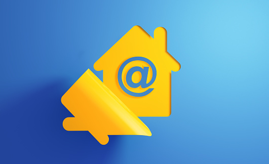Yellow house icon on blue background. There is an 'at' symbol on the chat bubble. Horizontal composition with copy space.