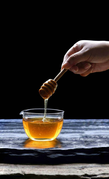 istock hand holding huney dipper stick 1188544239