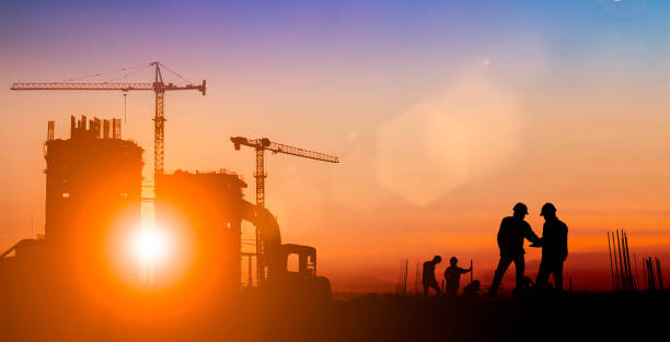 istock Silhouette of Survey Engineer and construction team working at site over blurred  industry background with Light fair.Create from multiple reference images together 1188545092