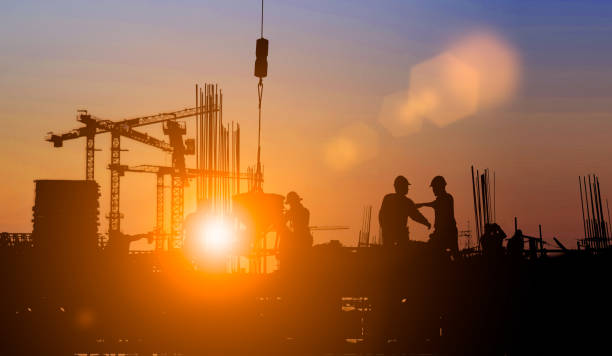 istock Silhouette of Survey Engineer and construction team working at site over blurred  industry background with Light fair Film Grain effect.Create from multiple reference images together 1188545097
