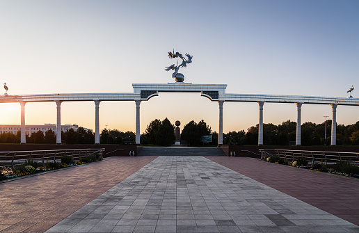 Tashkent, Uzbekistan - October 24th, 2019: View from Independence Square to sunset twilight over the Arch of Independence. Monument to the Independence of Uzbekistan - Mustaqillik Maydoni at Independence Square in the background. Independence Square, Tashkent, Uzbekistan, Central Asia.