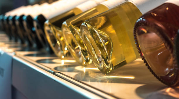 Bottles of wine on display with dramatic light on them. Bottles of wine on display with dramatic light on them, painted on the bottom, three different types of wine. wine shipping stock pictures, royalty-free photos & images
