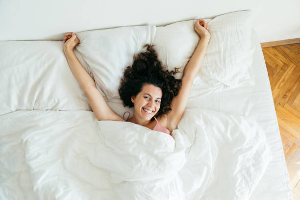 istock young pretty woman in bed with white sheets bright light copy space 1188554573
