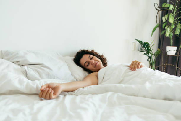 istock young pretty woman in bed with white sheets bright light copy space 1188554591