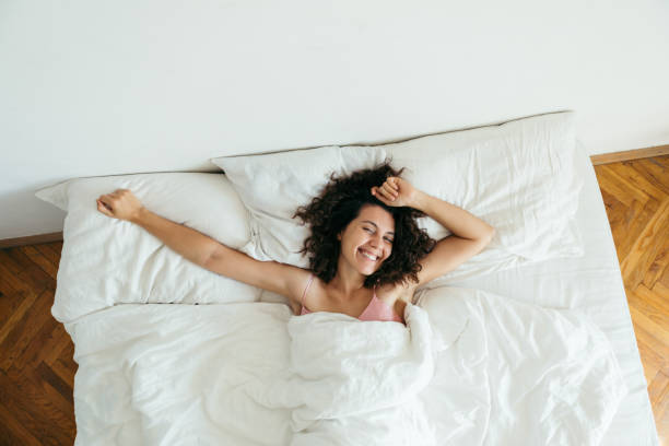 istock young pretty woman in bed with white sheets bright light copy space 1188554592