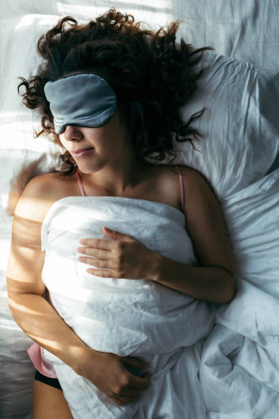 istock woman sleeping in mask in bed bright light on face morning time 1188554603