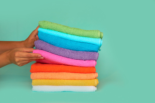 stack of multi-colored clean towels on a blue background.
