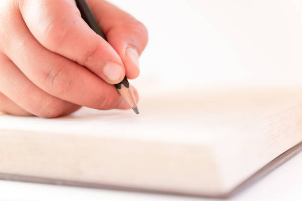istock A close up of a hand writing a book with a pencil 1188561241