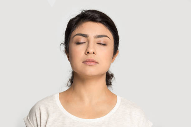 fille indienne calme avec les yeux fermés respirant profondément, méditant - close up human eye photography color image photos et images de collection