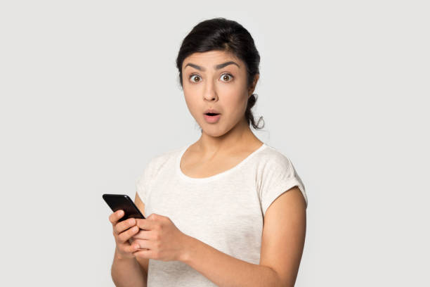 istock Head shot portrait surprised Indian girl using phone 1188562849