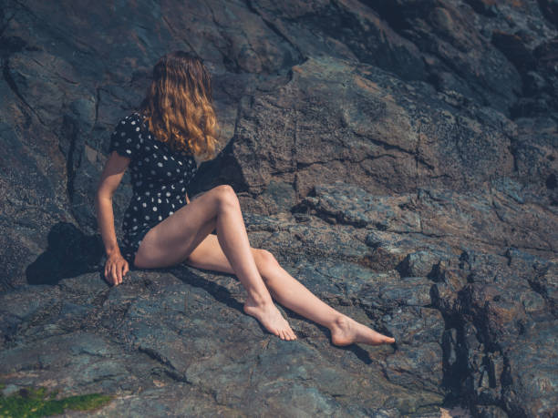 istock Woman sitting on rocks in summer 1188563183
