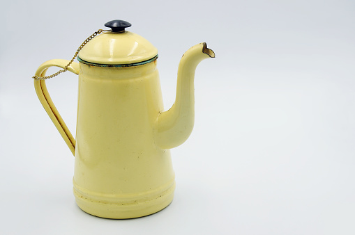 Vintage enamel pitcher is a pale yellow on white backgound, Place for text