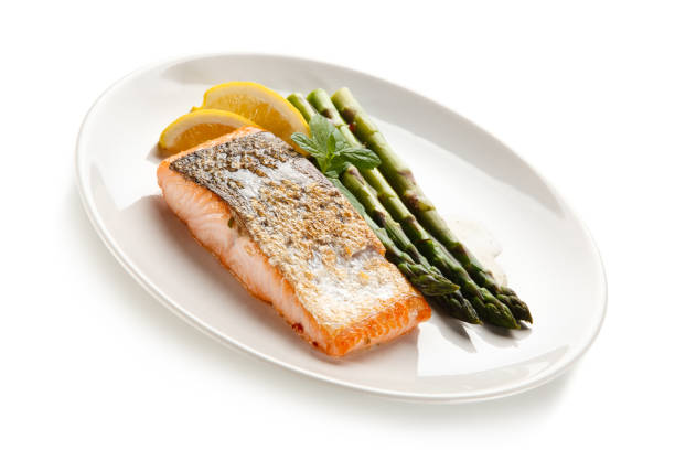 istock Fried salmon with asparagus on white background 1188565444