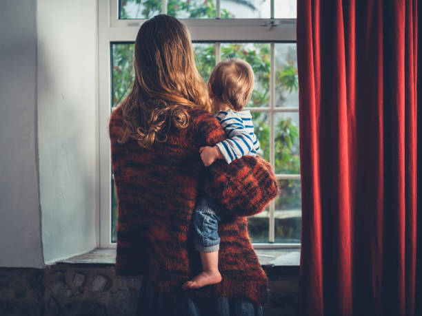 istock Mother with toddler by the window 1188565529