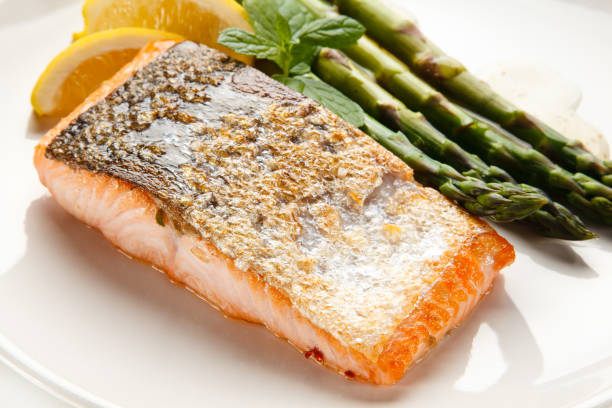 istock Fried salmon with asparagus on white background 1188566111