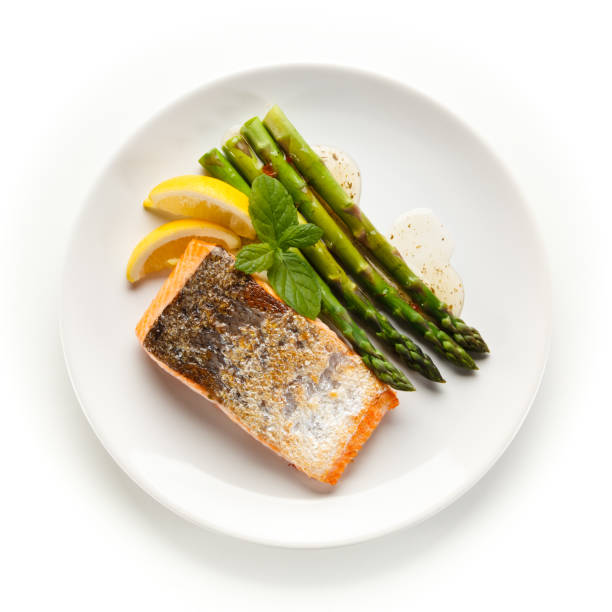 istock Fried salmon with asparagus on white background 1188566171