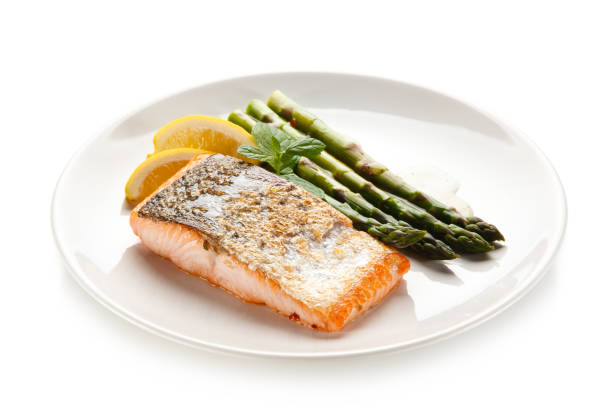istock Fried salmon with asparagus on white background 1188566220