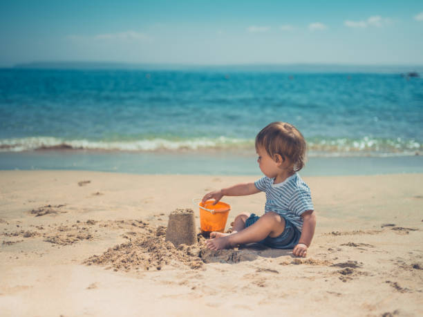istock Toddler on beach building sand castle 1188566302