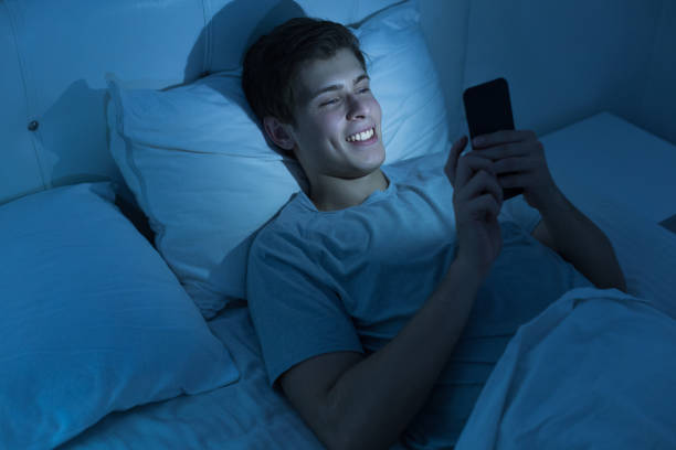 istock Young man with a phone in the bed 1188567770