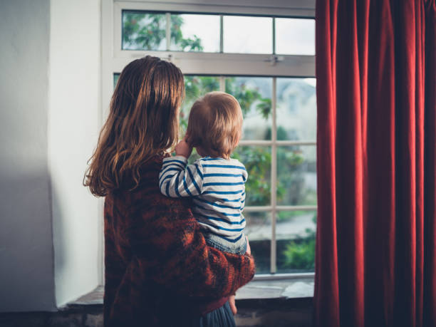 istock Mother with toddler by the window 1188568455