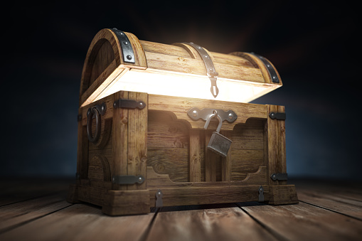 Vieja caja de cofre tesoro de madera con brillo desde el interior photo