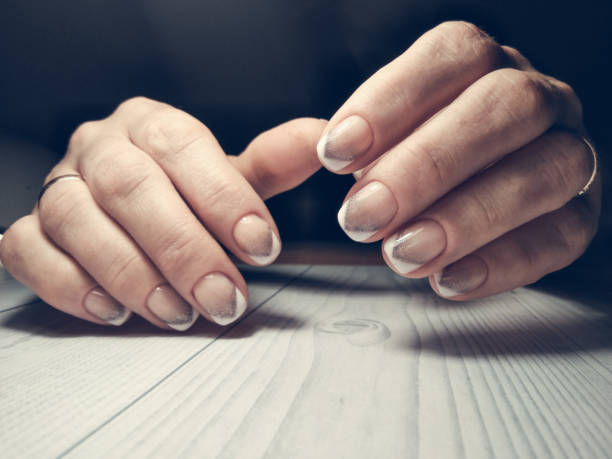 istock Unusual french manicure with silver topping. Gradient silver topping on a triangular geometric french manicure. 1188571688