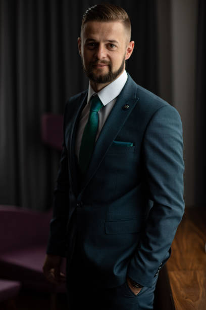istock Handsome man in suit standing by the window 1188573619