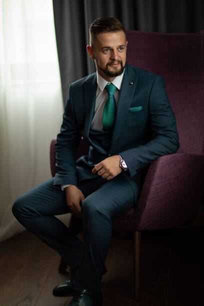 istock Handsome man in suit sitting in chair 1188575071