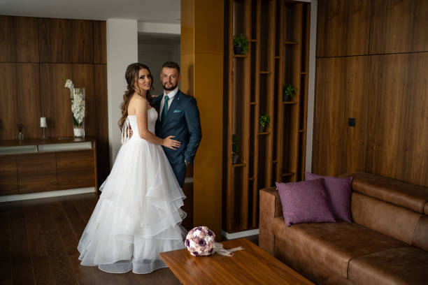 Chic wedding dress and veil on a mannequin in the bride 's gathering room. View through the doorway.