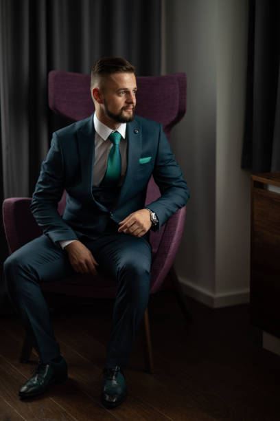 istock Handsome man in suit sitting in chair 1188576520