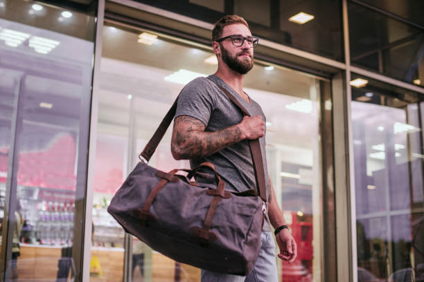 istock Handsome confident man with beard stands near city background with copy space for your text message or advertising, fashionable rich male dressed in expensive clothes posing outdoors 1188577324