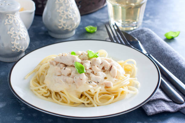 istock Spaghetti with chicken and cheese sauce on a white plate, horizontal 1188577757