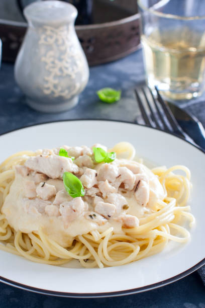 istock Spaghetti with chicken and cheese sauce on a white plate, selective focus 1188577765