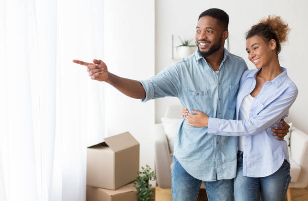 istock Afro Husband Showing Wife Window View Hugging In Own Flat 1188578180