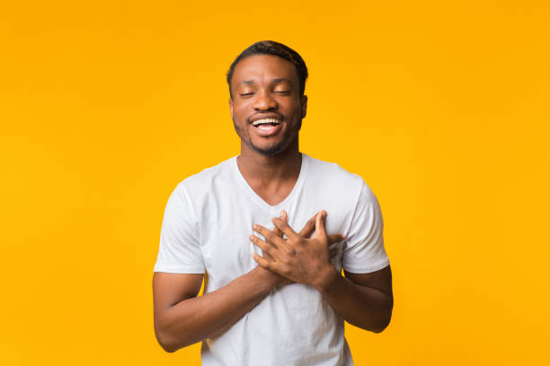 istock Touched Black Man Pressing Hands To Chest Standing, Yellow Background 1188579665