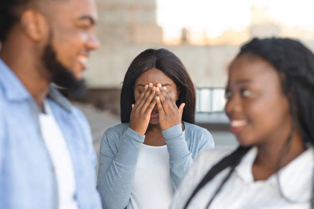 schwarze frau bedeckt gesicht mit händen, eifersüchtig auf ihre dating-freunde - disgust women african ethnicity human face stock-fotos und bilder