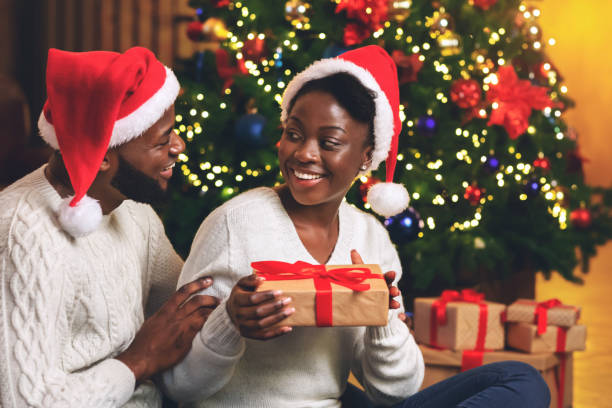 istock Caring afro man surprising his girlfriend with Christmas gift 1188582411