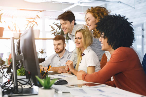 istock Young motivated team looking at computer screen in office together 1188582783