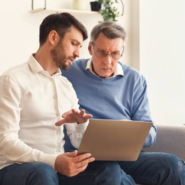 istock Son Teaching Senior Father Computer Literacy Sitting On Sofa Indoor 1188585814