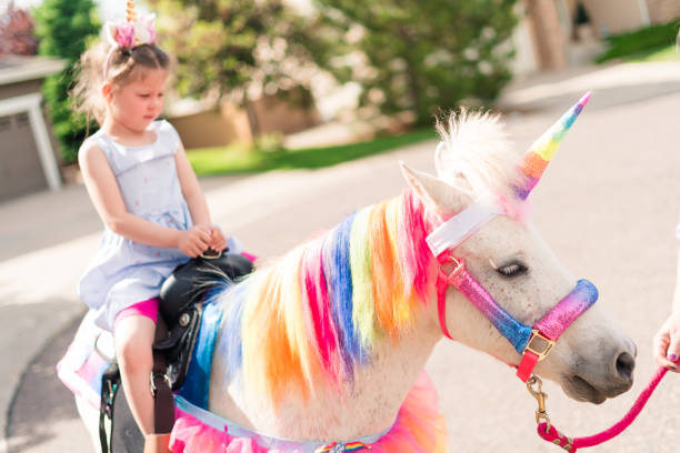 istock Little girl riding a unicorn 1188587468