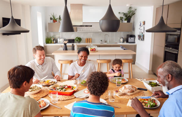 istock Multi-Generation Mixed Race Family Eating Meal Around Table At Home Together 1188588662